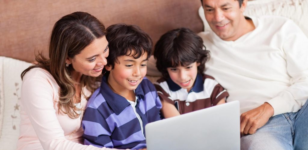 papas e hijos viendo una computadora